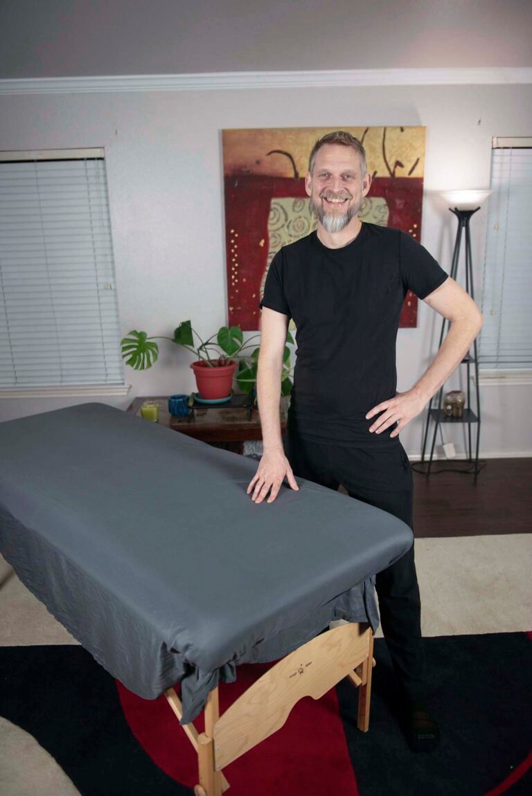 Practitioner beside a prepared treatment table before a first session